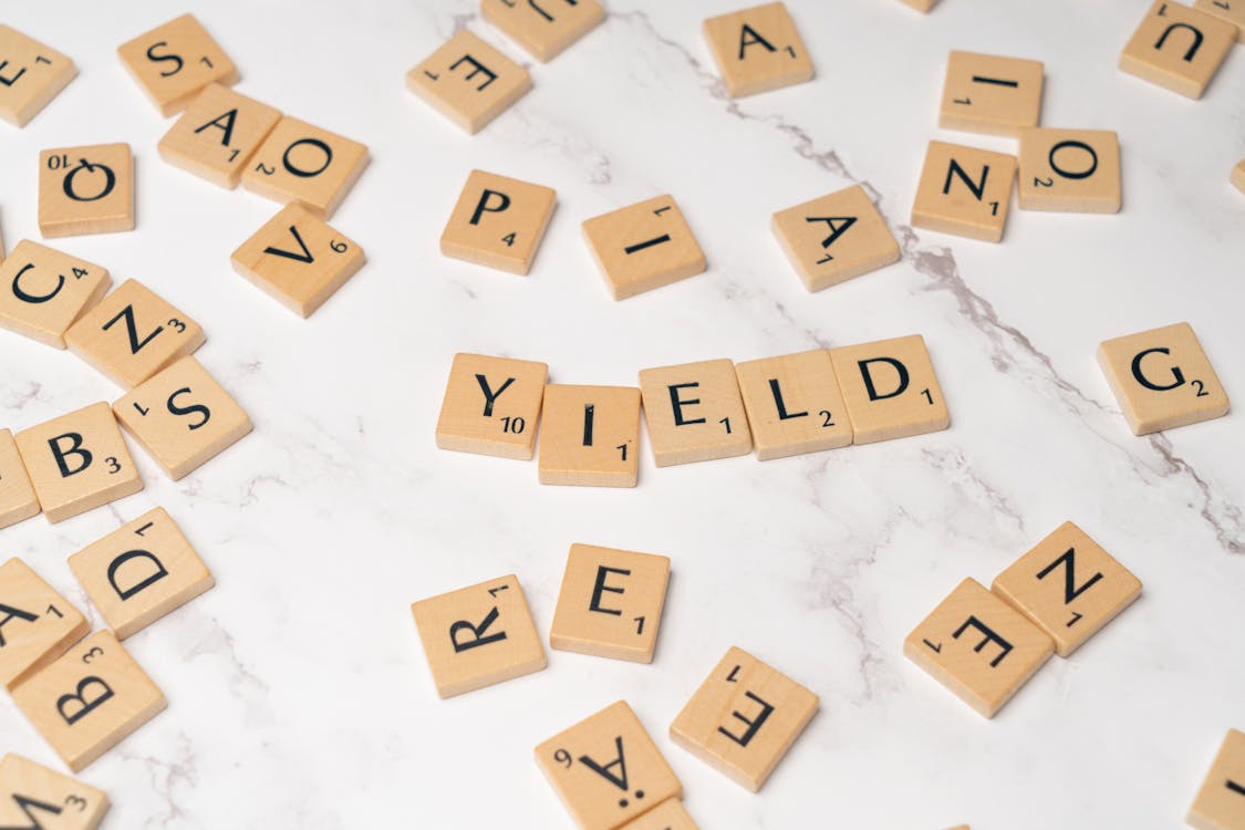 Free Scrabble letters spelling yield on a white table Stock Photo